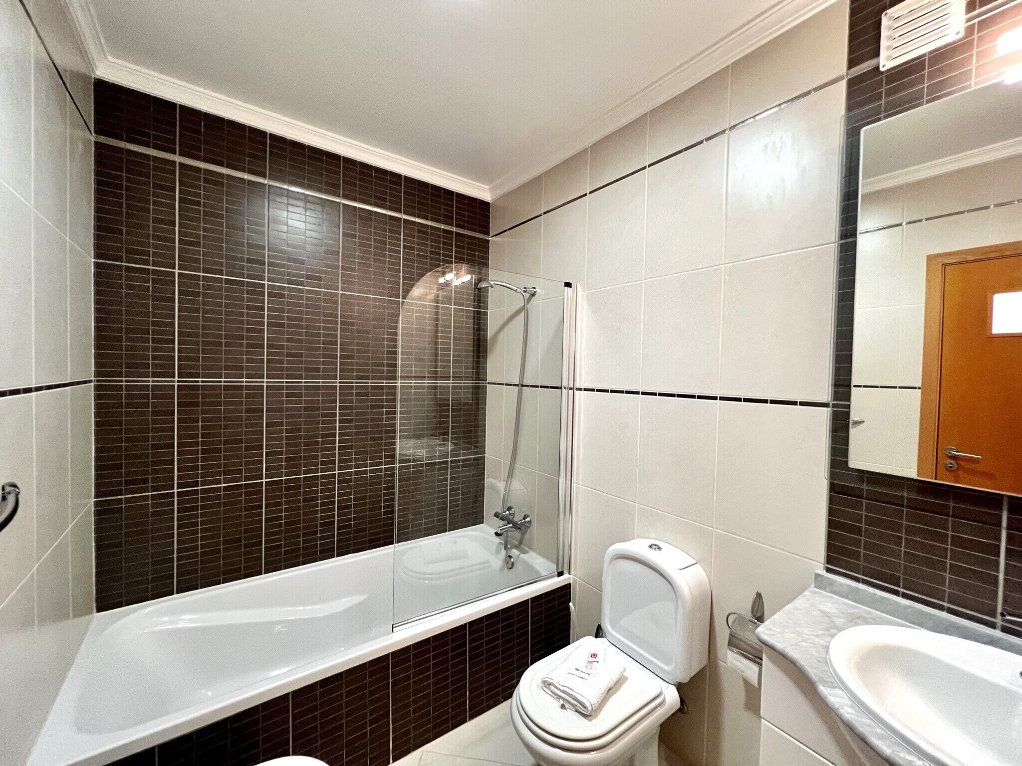 A bathroom with a bathtub, toilet, and sink.