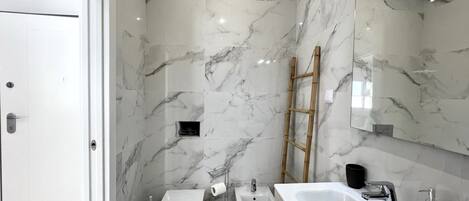 A modern bathroom with a toilet, bidet, and sink.