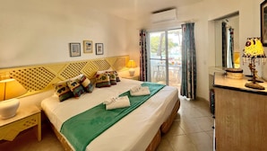 A hotel room with a bed, a desk, a chair, a lamp, and a window with curtains. - Albufeira Balaia Golf Village 2 (Albufeira)