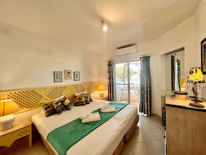 A hotel room with a bed, a desk, a chair, a lamp, and a window with curtains. - Albufeira Balaia Golf Village 2 (Albufeira)