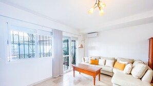 A spacious living room with a large window, a sofa, and a coffee table.