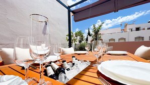A table set for dining with wine glasses, bottles, and plates, overlooking a cityscape.