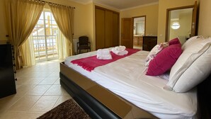 A hotel room with a bed, a chair, a dresser, a mirror, and a window with curtains. - Pêra Amazing Villa With Pool by Homing (Silves)