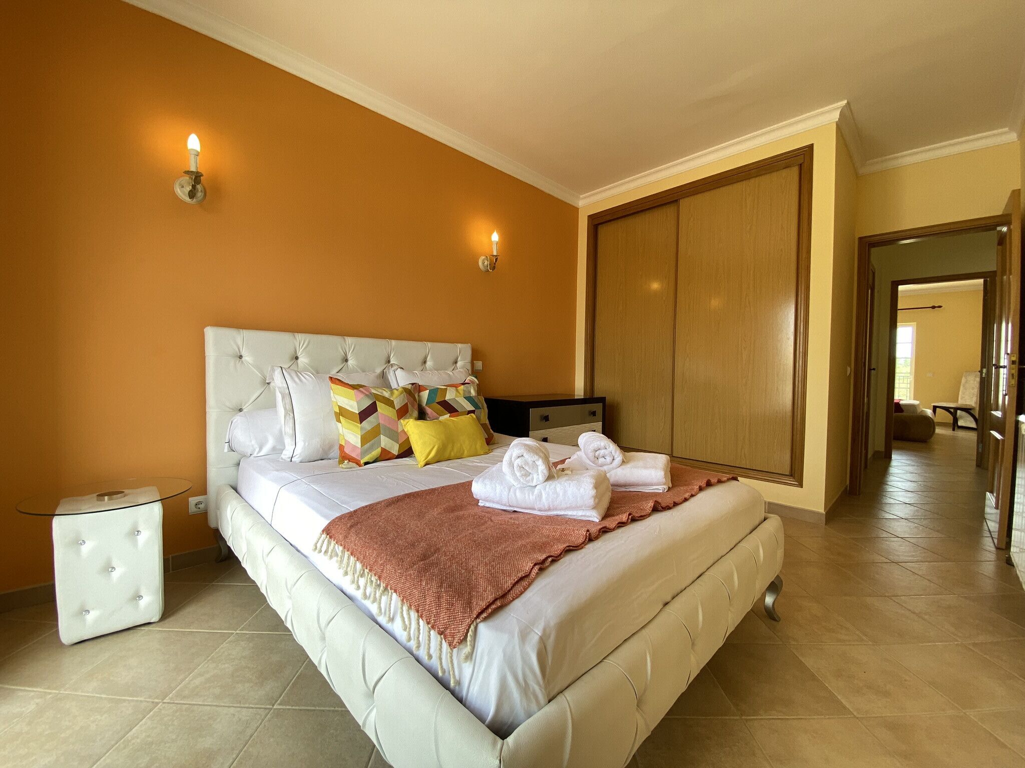 Une chambre à coucher avec un grand lit, une armoire et une table de chevet.