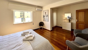 Ein Hotelzimmer mit Bett, Schreibtisch, Stuhl, Fenster und Tür.