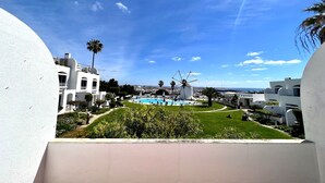 A resort with a pool, palm trees, and a windmill. - Albufeira Sunset With Pool by Homing (Albufeira)