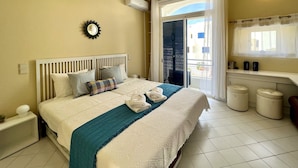 A hotel room with a bed, a bedside table, a mirror, an air conditioning unit, a window with curtains, and a small balcony. - Albufeira Sunset With Pool by Homing (Albufeira)