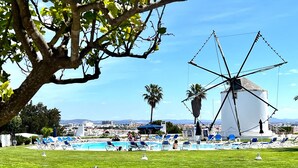 A windmill, a pool, and lounge chairs in a sunny outdoor setting. - Albufeira Sunset With Pool by Homing (Albufeira)