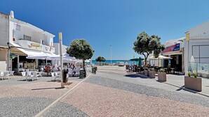 A cobblestone street with outdoor seating, a bar, and shops. - Albufeira Valley 2 With Pool by Homing (Albufeira)
