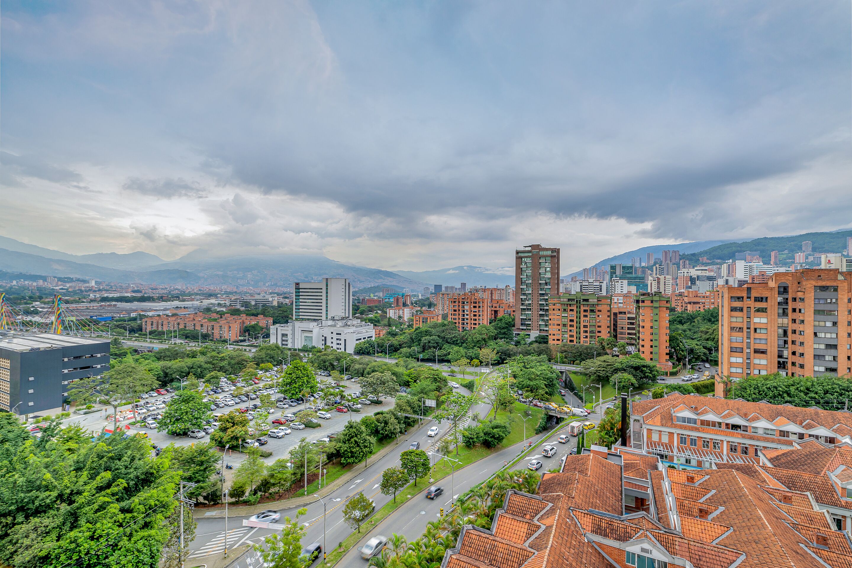 Un horizonte urbano que combina arquitectura moderna y tradicional, con rascacielos y zonas residenciales con tejados de tejas rojas.