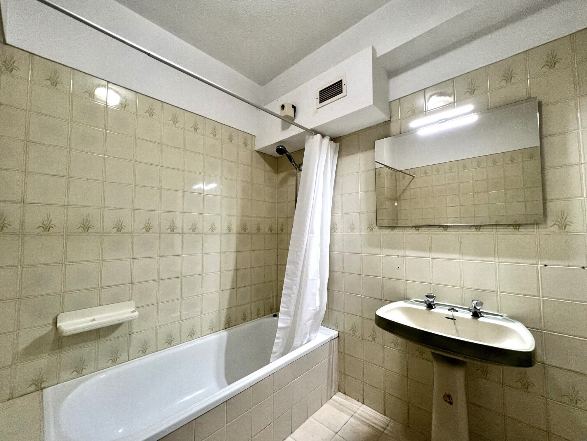 Un baño con bañera, lavamanos y espejo.
