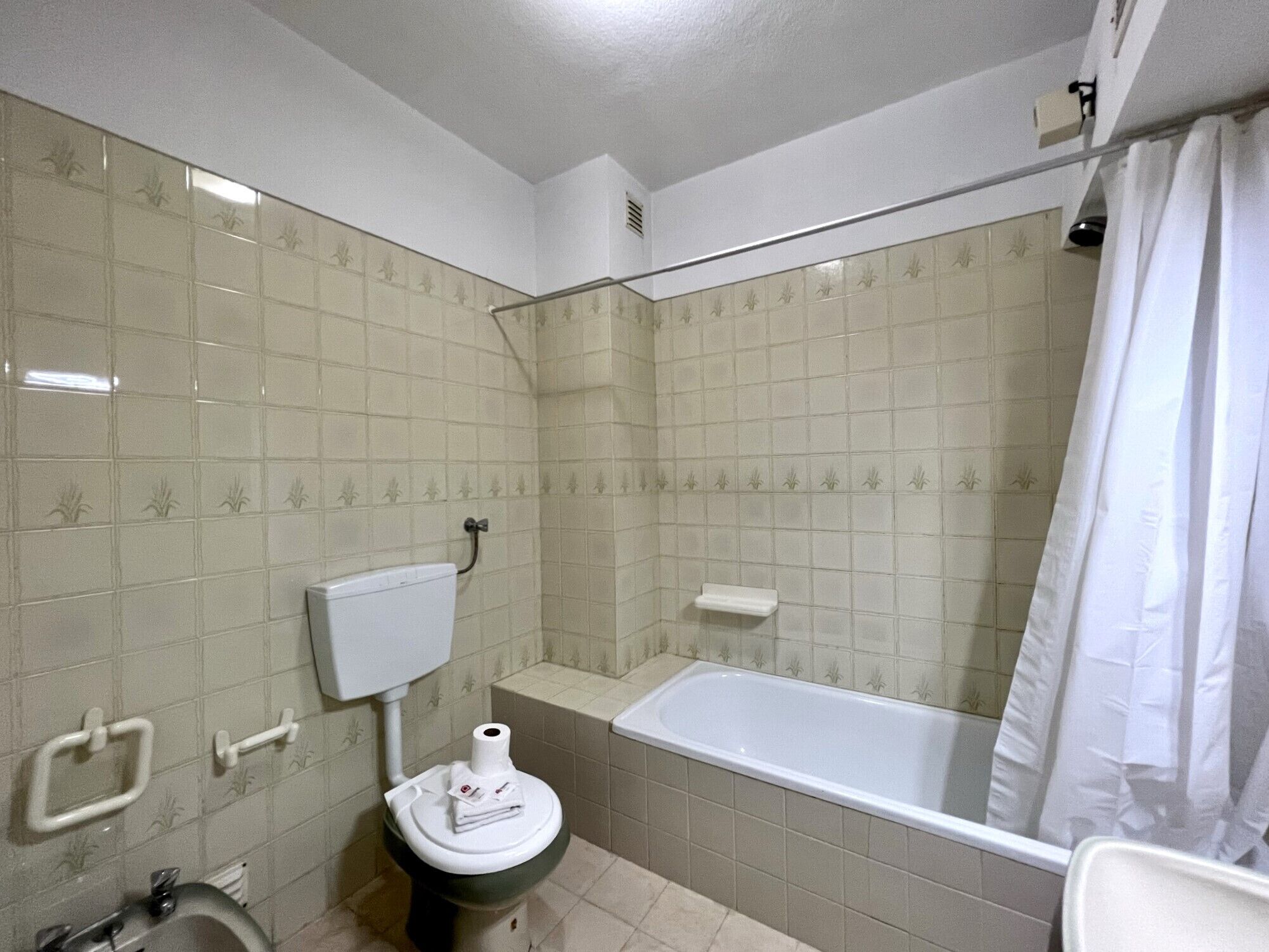 A bathroom with a toilet, a sink, and a bathtub.