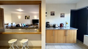 Une cuisine moderne dotée d’un plan de travail, de placards et d’un coin repas avec un canapé et des chaises.