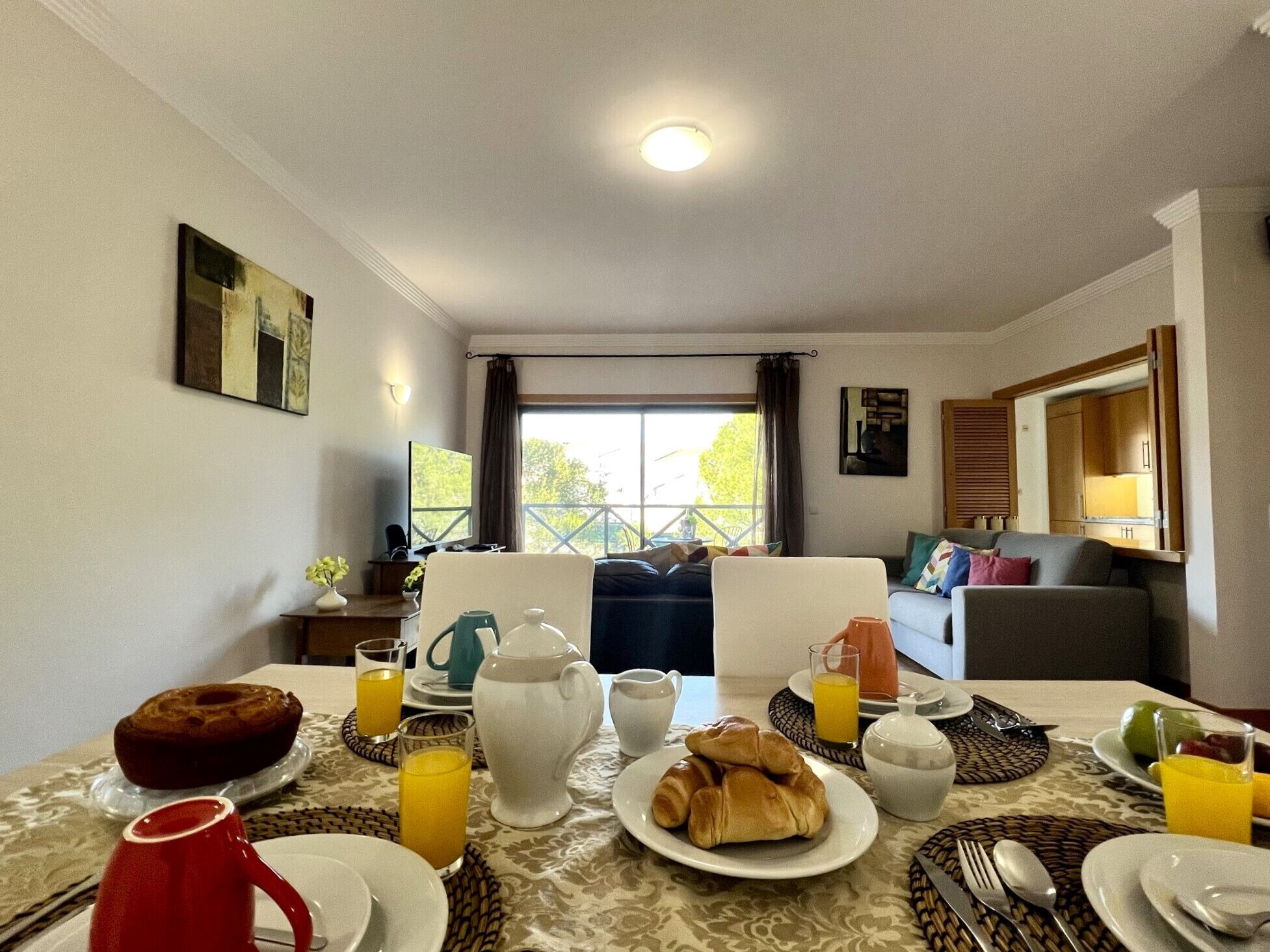 A breakfast setup with plates, croissants, and orange juice on a table.
