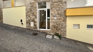 A building with a stone facade, a ground floor entrance, and a small window.