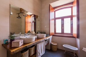 A bathroom with two sinks, a mirror, a bathtub, and a window with curtains. - Pêra Vintage Villa With Pool by Homing (Silves)