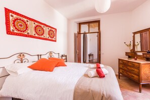 A neatly made bed with white and orange bedding, a wooden dresser, and a mirror. - Pêra Vintage Villa With Pool by Homing (Silves)