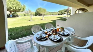 Una mesa preparada para el desayuno con vistas a un área verde y árboles.