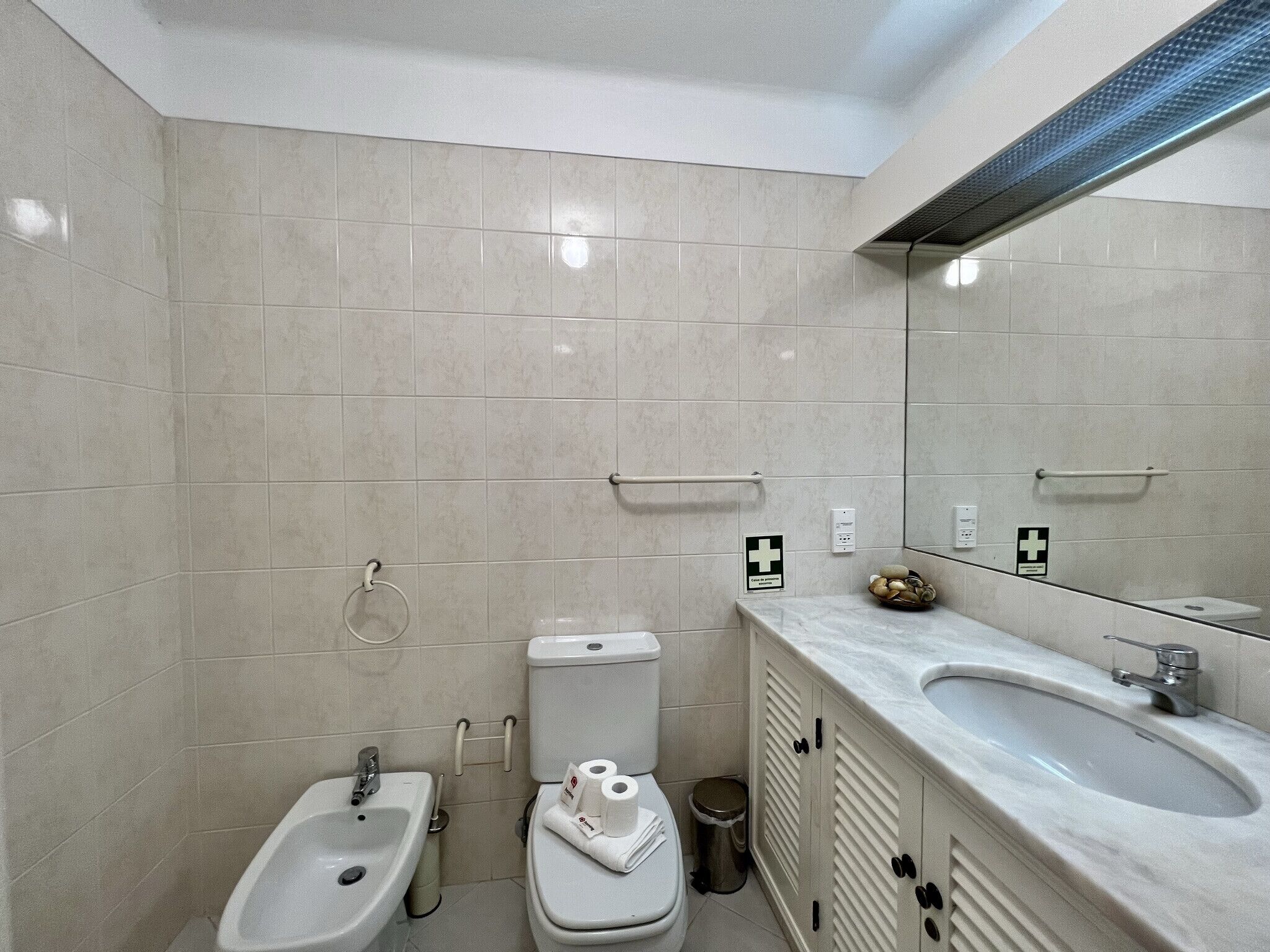Een moderne badkamer met toilet, bidet en wastafel.