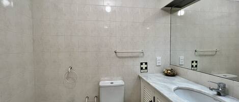 Een moderne badkamer met toilet, bidet en wastafel.