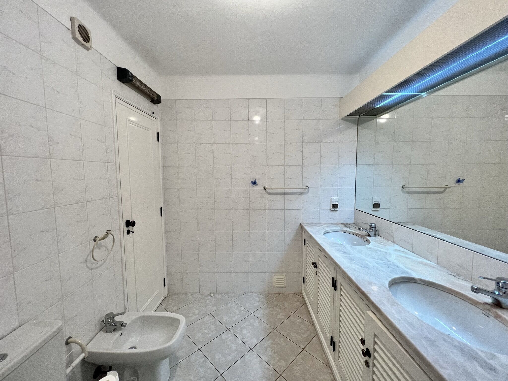 Un baño moderno con un lavamanos grande, espejo y zona de ducha.