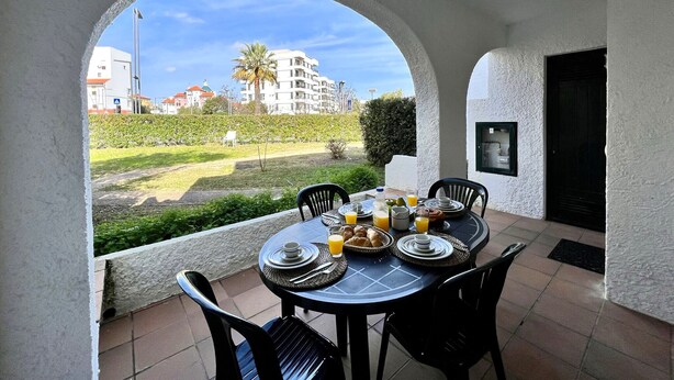 A dining area with a table set for breakfast, including plates, cutlery, and a basket of croissants. - Vilamoura SEA Village by Homing (Loulé)