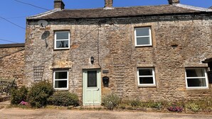 A stone building with a green door, multiple windows, and a satellite dish. - Spacious detached holiday home, sleeps 7 with 2 furry friends, free WiFi, two pubs nearby. (Richmond)