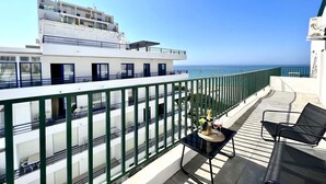 Un balcone con tavolo, sedie e vista sul mare.