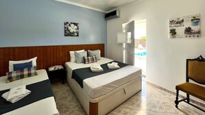 A hotel room with two beds, a wooden headboard, a small table, and a chair. - Tavira Vila Formosa 5 With Pool (Tavira)