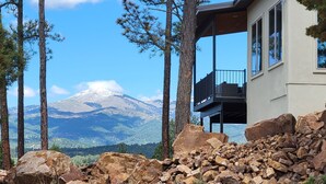 A mountain cabin with a balcony overlooking a snowy mountain, surrounded by trees and rocks. - Viewtopia by Ruidoso Vacation Rentals (Ruidoso)