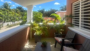 Ein Balkon mit Blick auf Palmen und ein Gebäude im Hintergrund.
