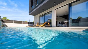 A modern house with a swimming pool, large windows, and outdoor furniture. - Pet friendly home in Vodice with sauna (Vodice)