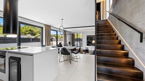 A modern kitchen with a central island, large windows, and a staircase with a metal railing. - Pet friendly home in Vodice with sauna (Vodice)