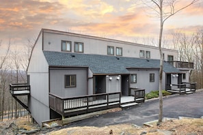 A modern two-story building with a grey facade, multiple windows, and a balcony. - Poconos Camelback Retreat-Pet Friendly, Pool, Camelbeach Waterpark, Outlet Mall (Tannersville)