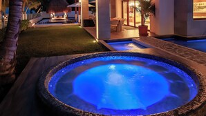 Une maison moderne avec une piscine, au crépuscule.
