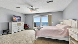 Ein Schlafzimmer mit Bett, Schminktisch, Fernseher, Sessel und einem Balkon mit Blick.