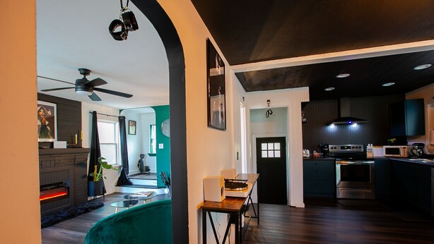 A modern kitchen with a microwave, oven, and dining area. - An Alluring Escape (Cincinnati)
