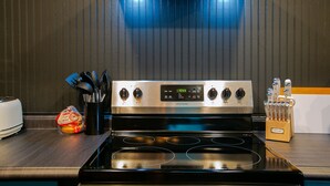 A kitchen with a stainless steel stove, a loaf of bread, and a knife block. - An Alluring Escape (Cincinnati)