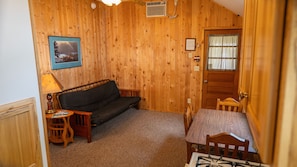 Cozy room with a sofa, table, and chair, perfect for a straightforward stay.