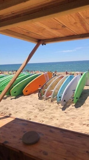 A beach with surfboards lined up under a wooden shelter. - Villa Lege Cap Ferret Avec Piscine et Spa, à 5 Minutes de la Plage ! (Lège-Cap-Ferret)