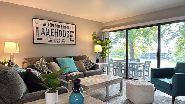 Una sala de estar moderna con un sofá, una mesa de centro y un letrero que dice "Welcome to our Lakehouse".