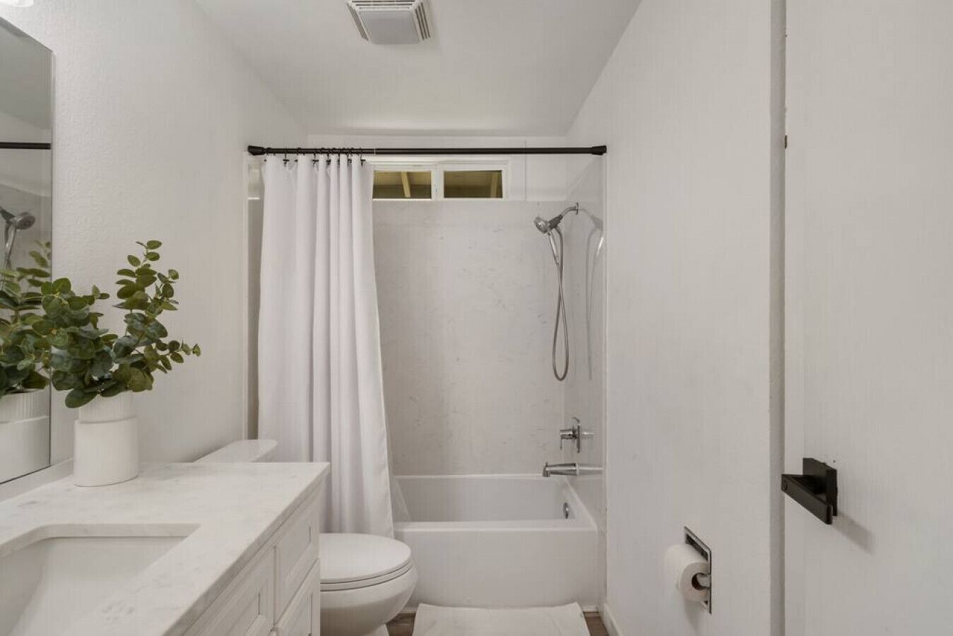 A bathroom with a shower, toilet, and sink.