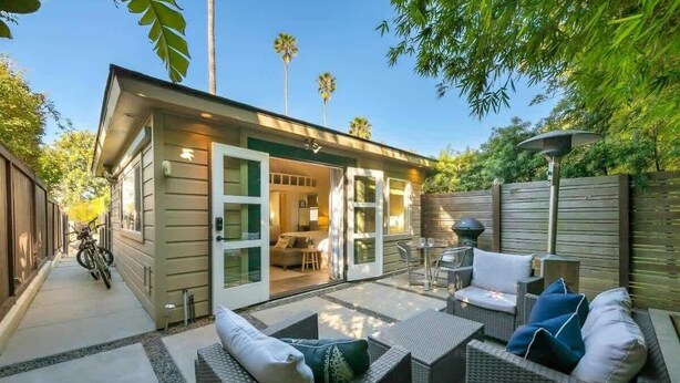 A small house with a patio, outdoor seating, and a garage. - Secluded Windansea Beach Rental Cottage (La Jolla)