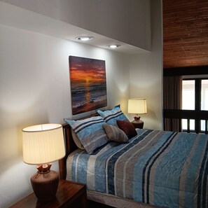 A bedroom with a bed, two bedside lamps, a painting, and a window with curtains. - Peaceful contemporary condo near Disney, pet friendly. 1  1/2 Baths (Haines City)