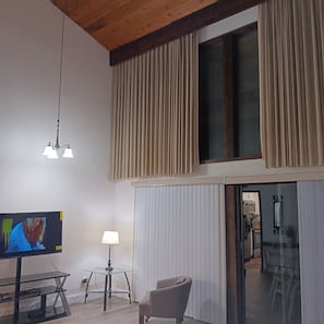 A modern living room with a television, a lamp, and a chair. - Peaceful contemporary condo near Disney, pet friendly. 1  1/2 Baths (Haines City)