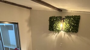 Un baño moderno con una bañera grande, suelo de madera y una puerta de cristal que da a un balcón.