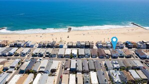 An aerial view of a coastal residential area with a beach in the background.