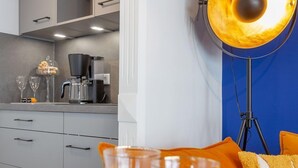 A modern kitchen with a coffee machine, wine glasses, and a tray with fruits. - Schickes Stranddomizil in der 3. Etage, in Direkter Lage zum Strand - Andreas-dirks-straße 5 (Sylt)