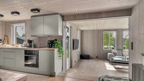 A modern kitchen with grey cabinets, a built-in oven, and a coffee maker. - Bjørkstue by Interhome (Eikerapen)