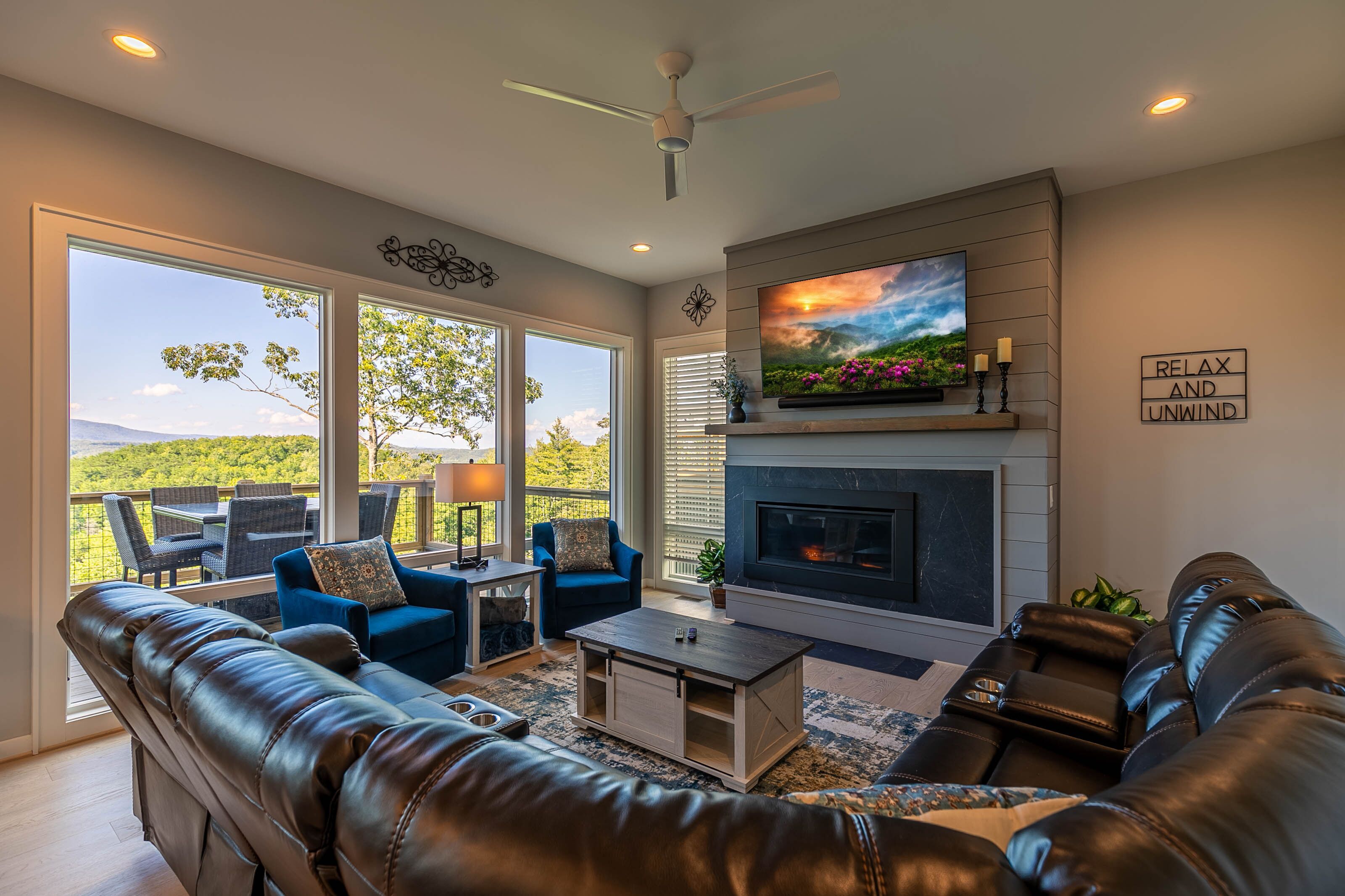 A living room with a fireplace, leather sofas, a coffee table, and a TV.
